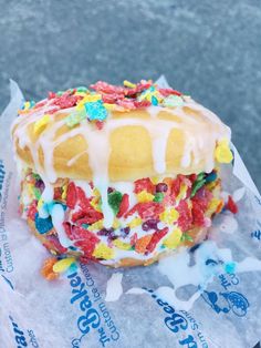 a donut covered in sprinkles and frosting on top of a wrapper