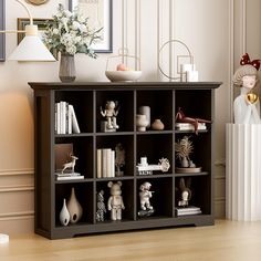 a shelf with many different items on it in a room next to a vase and lamp