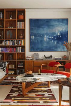 a living room filled with furniture and bookshelves next to a painting on the wall