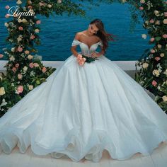 a woman in a white wedding dress standing next to flowers