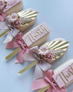 four pink and gold hair combs with name tags on them, decorated with flowers