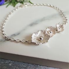 Handmade silver flower bracelet. A beautiful floral bracelet ideal for gifting at birthdays, anniversaries, Valentines day and special occasions. Handmade from solid sterling silver, features 3 individual flowers, one larger and two smaller with hammered petals that are twisted by hand in to shape. Fastens with a sterling silver lobster clasp with a lovely tactile sterling silver belcher chain. Your bracelet will arrive wrapped in tissue paper inside a ribbon tied box, perfect for gifting at bir Silver Flower Bracelet, Individual Flowers, Silver Jewelry Accessories, Ivory Earrings, Belcher Chain, Metalwork Jewelry, Wedding Day Gifts, Bridal Earrings Drop, Bracelet Pandora