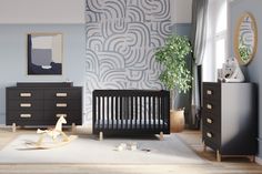 a baby's room with a crib, dresser and wallpaper in shades of blue