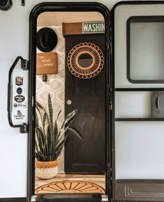 the interior of a trailer with a door and potted plant