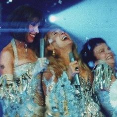 three women in sequins are laughing together