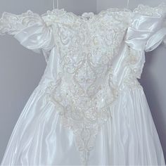 a white wedding dress hanging on the wall