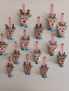 christmas decorations made out of toilet paper hanging from the wall with reindeer faces on them