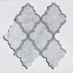 a white and grey tile with an intricate design