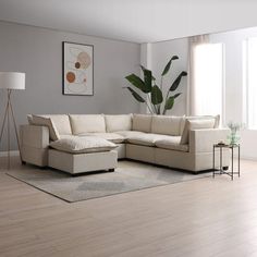 a living room with a large sectional couch and potted plant in the corner on the wall