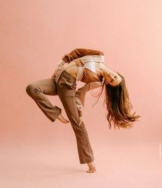 a woman is doing a handstand in front of a pink background