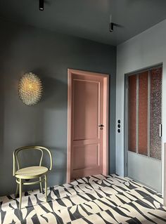 a chair sitting in front of a pink door