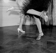 a woman is dancing on the floor with her legs spread out in front of her