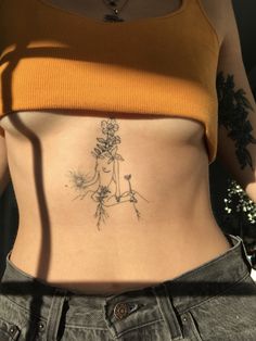 a woman's stomach with a tattoo on the side, and an image of flowers