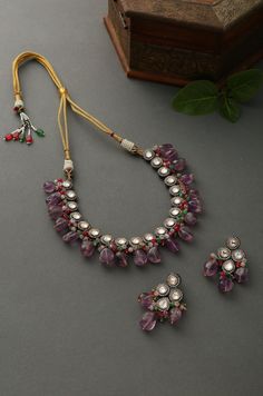 Floral uncut victorian polki choker necklace set with studs embellished with purple amethyst stones. Necklace Size - 16 inches. Closure - Dori Earrings - 5cm Style Tip - When it comes to getting a classic look, nothing can be better than silver victorian necklace set. For a party or a wedding, you can opt for this necklace set and grab all the attention. They look best with solid-colored clothing. Handcrafted in Jammu and Kashmir Paisley Pop travels the depths of India to learn techniques and cr Polki Choker, Victorian Necklace, Amethyst Stones, Stone Choker, Choker Necklace Set, Kundan Necklaces, Set Necklace, Wedding Jewellery Necklace, Jewelry Choker