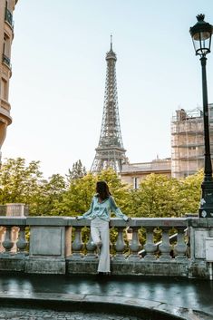 a woman standing on a bridge near the eiffel tower in paris, france