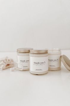 three jars with thank you written on them sitting next to a spoon and napkins