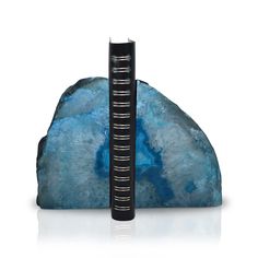 a bookend made out of rocks with a blue rock in the foreground and a black book on top