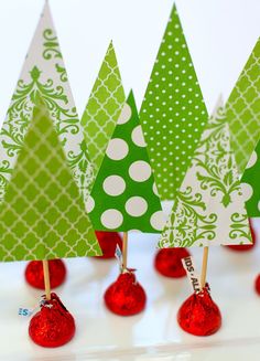 small christmas trees are lined up in red and green candies on a white surface