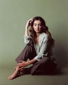 a woman sitting on the ground with her legs crossed