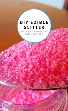 a bowl filled with pink glitter sitting on top of a wooden table