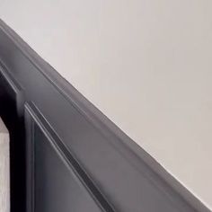 the corner of a room that is painted white and has an open door on it