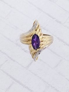 Vintage Amethyst & Diamond ring. Details: Size: US 6 1/2 ( Can be sized ) Weight: 4.4 grams Primary stone: Amethyst Stone Shape: Marquise ( Appx. 10mm x 5mm ) Secondary Stone: Diamond Stone Shape: Round Metal: 14k Yellow Gold Condition: Brand new Inside of band is stamped and tested for '14k' gold. SIZING: Currently this ring is a size 6 1/2 but could be sized up or down for an additional small fee if desired by adding custom ring sizing to your cart upon checkout. Most sizing can be done wi Purple Amethyst Birthstone Ring For Formal Occasions, Formal Purple Amethyst Birthstone Ring, Elegant Multi-stone Amethyst Collectible Ring, Fine Jewelry Purple Rings With Diamond Accents, Formal Purple Diamond Birthstone Ring, Formal Purple Birthstone Gemstones, Elegant Purple Amethyst Ring With Marquise Cut, Purple Marquise Jewelry For Formal Occasions, Elegant Purple Marquise Cut Amethyst Ring