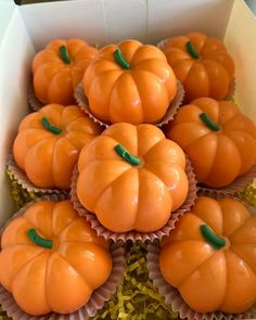 small orange pumpkins sitting in a white box