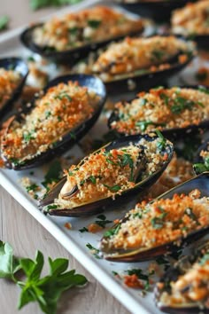 a tray filled with cooked mussels covered in parmesan cheese and herbs