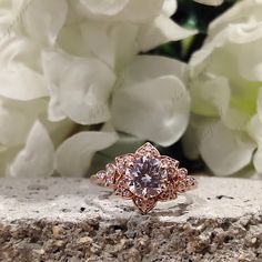 a close up of a ring with flowers in the background