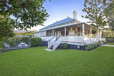 a white house sitting on top of a lush green field