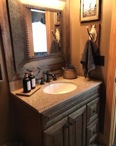 a bathroom with a sink, mirror and other items on the counter in front of it