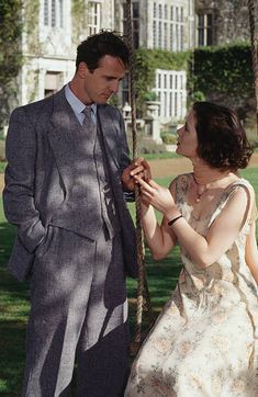 a man standing next to a woman on a swing