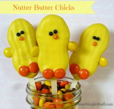 three candy birds sitting on top of each other in a glass jar filled with candy