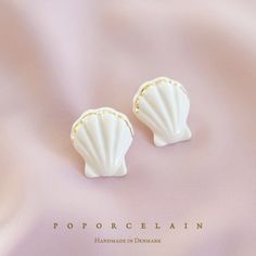 Porcelain Clam Shell Statement Stud Earrings SKU: E_036/E_036C PRODUCT INFO Sea-inspired shell earrings are a must-have in your seasonal wardrobe. They would love to be with you to enjoy the sandy beach and ocean waves. Every porcelain shell is moulded and handcrafted from a natural clamshell. Shells are hand-painted with gold lustre. Due to the necessity of the making process, a small area on the back side of the shell is unglazed. Please do not consider it as a defect. (Clip-on ear fastening, Elegant Shell-shaped Clip-on Earrings For Gift, Elegant White Shell Earrings, Shell-shaped Clip-on Earrings For Gift, Elegant Shell-shaped Clip-on Earrings As Gift, Elegant Handmade White Shell, White Shell-shaped Shell Earrings, White Shell-shaped Pearl Earrings, White Shell-shaped Mother Of Pearl Earrings, White Shell Drop Earrings