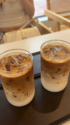 two iced drinks sitting on top of a table