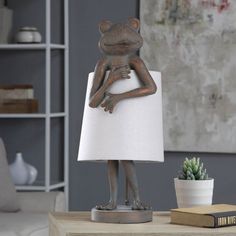 a lamp that is sitting on top of a table next to a potted plant