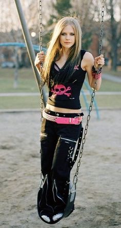 a woman is swinging on a swing in a playground with chains and pink bras