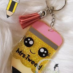 a keychain that has a cup on it with a tassel hanging from it