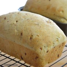 two loafs of bread sitting on top of a cooling rack