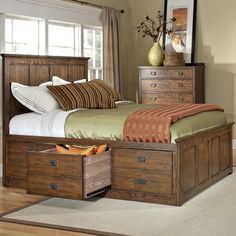 a bed with drawers underneath it in a bedroom