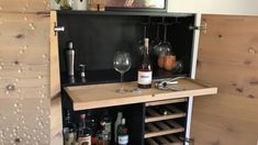 a cabinet with wine glasses and bottles on it