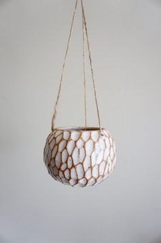 a white vase hanging from a rope