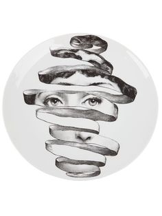 a plate with an image of a woman's face wrapped in strips of ribbon