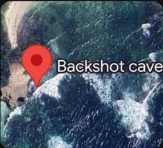 an aerial view of the beach and ocean with a red marker that says backshot cave