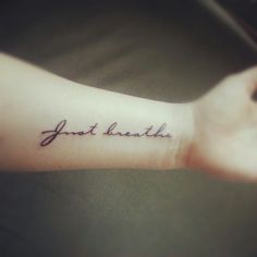 a person with a tattoo on their arm that says, just breathe