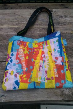 a colorful bag sitting on top of a wooden bench