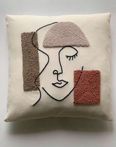 a decorative pillow with a woman's face on the front and two squares in the back