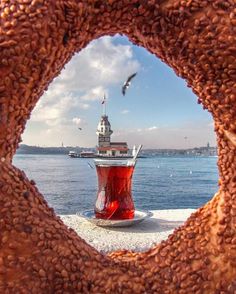 a large doughnut with a red cup in the middle and seagulls flying over it