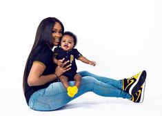 a woman sitting on the ground holding a baby