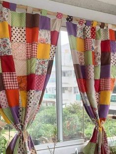 the window is decorated with colorful patchwork curtains